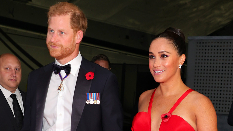 Le prince Harry en smoking et Meghan Markle en robe rouge