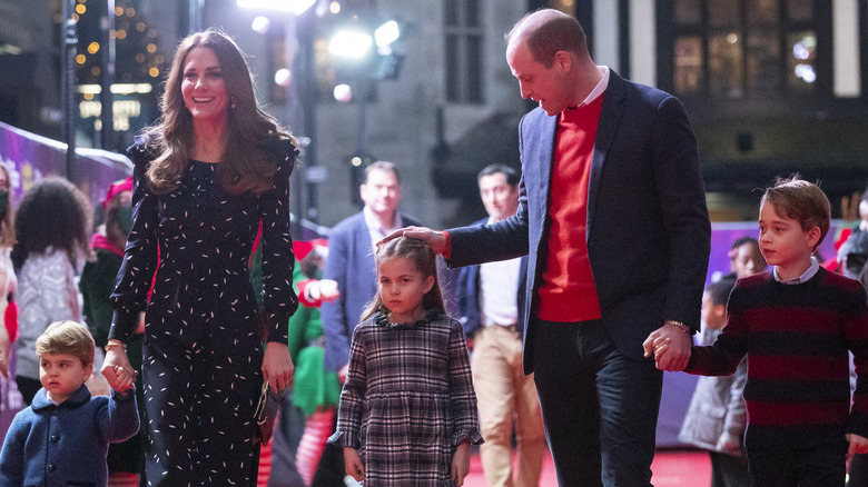 Le prince William et Kate Middleton se tiennent la main et rient avec leurs enfants