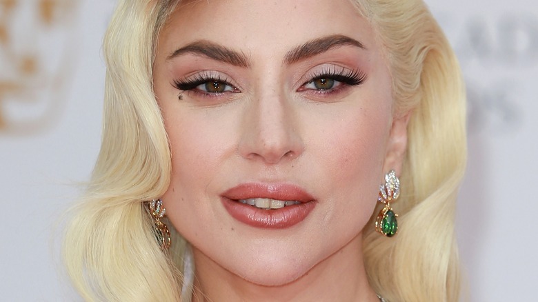 Lady Gaga porte des boucles d'oreilles pendantes vertes