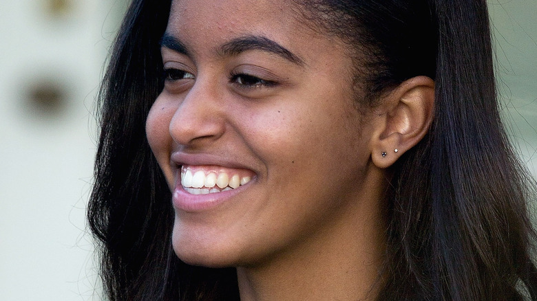Malia Obama sourit en détournant les yeux de la caméra