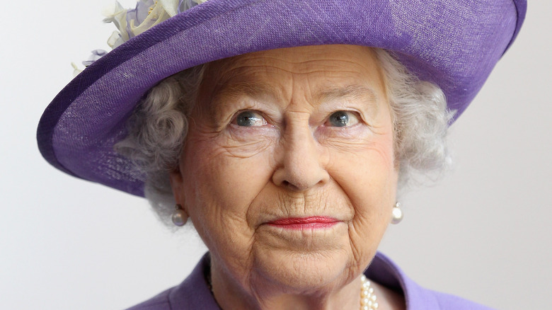 Chapeau violet souriant de la reine Elizabeth II