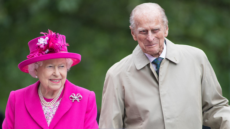 La reine Elizabeth II en costume rose avec le prince Phillip