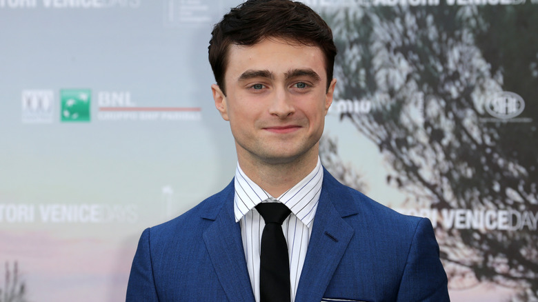 Daniel Radcliffe en costume souriant pour une photo