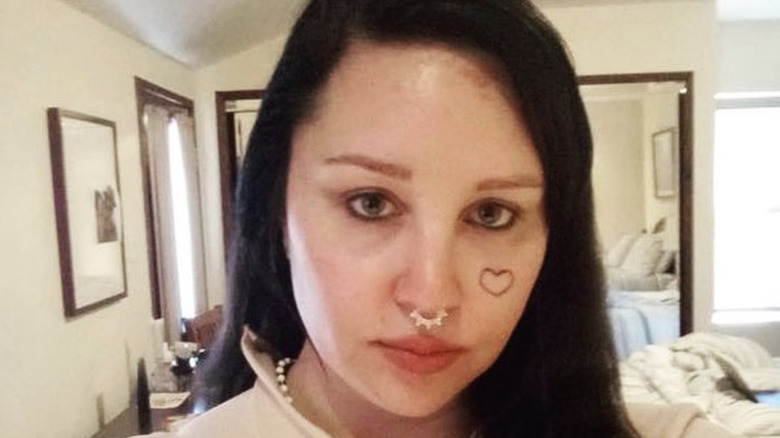 Amanda Bynes triste avec un tatouage de coeur sur le visage