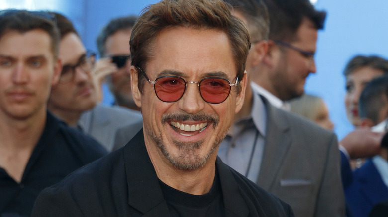 Robert Downey Jr. souriant avec des lunettes de soleil