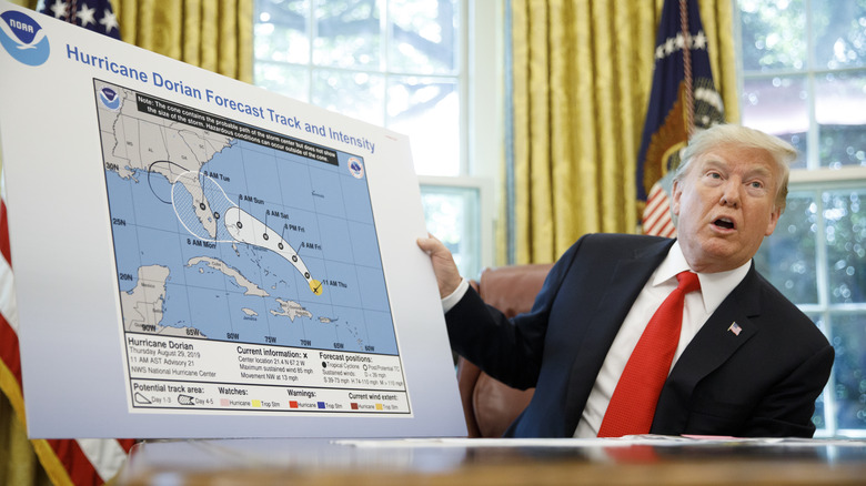 Donald Trump tenant une carte des ouragans