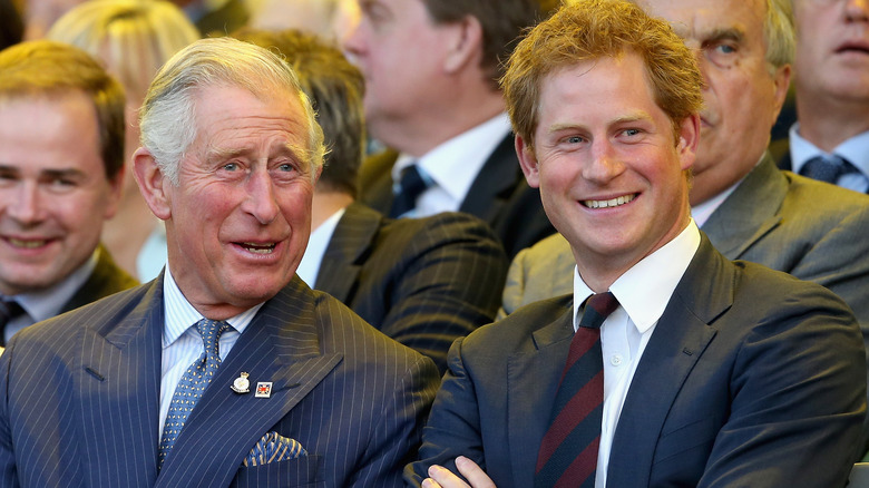 Le roi Charles et le prince Harry souriant 